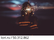 the girl is holding a sparkler on the beach. Стоковое фото, агентство Ingram Publishing / Фотобанк Лори