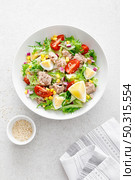 Tuna salad with boiled egg, tomato, lettuce, corn and red onion. Healthy and detox food concept. Ketogenic diet. Fresh vegetable salad bowl on white background. Top view. Стоковое фото, агентство Ingram Publishing / Фотобанк Лори