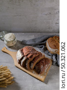Slices of homemade beetroot bread, and crispy wheat and rye bread. On a wooden board. Стоковое фото, агентство Ingram Publishing / Фотобанк Лори