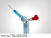 Vaccine and vaccination power as a medical concept as a punching glove emerging out of a needle as a symbol for immune defense and preventive drug treatment or virus infection with 3D elements. Стоковое фото, агентство Ingram Publishing / Фотобанк Лори
