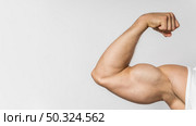 front view fit man showing bicep with copy space. Стоковое фото, агентство Ingram Publishing / Фотобанк Лори