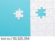 single white jigsaw puzzle piece blue background . Resolution and high quality beautiful photo. single white jigsaw puzzle piece blue background . High quality and resolution beautiful photo concept. Стоковое фото, агентство Ingram Publishing / Фотобанк Лори