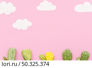small cactuses with paper clouds table. Resolution and high quality beautiful photo. small cactuses with paper clouds table. High quality and resolution beautiful photo concept. Стоковое фото, агентство Ingram Publishing / Фотобанк Лори