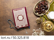 quran prayer beads wooden table. Resolution and high quality beautiful photo. quran prayer beads wooden table. High quality beautiful photo concept. Стоковое фото, агентство Ingram Publishing / Фотобанк Лори