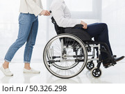 low section woman pushing man sitting wheelchair. Resolution and high quality beautiful photo. low section woman pushing man sitting wheelchair. High quality beautiful photo concept. Стоковое фото, агентство Ingram Publishing / Фотобанк Лори