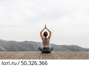 Back view of woman doing yoga outdoors Picture on pik. Resolution and high quality beautiful photo. Back view of woman doing yoga outdoors Picture on pik. High quality beautiful photo concept. Стоковое фото, агентство Ingram Publishing / Фотобанк Лори
