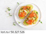 Open sandwiches with salted salmon, guacamole avocado and microgreens. Seafood. Healthy food. Top view. Стоковое фото, агентство Ingram Publishing / Фотобанк Лори