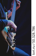 A close-up of a musician's hands skillfully playing a five-string bass guitar. In the center of attention are fingers deftly playing the strings, illuminated by stage light. Jazz concert. Стоковое видео, видеограф Воловодов Владимир / Фотобанк Лори