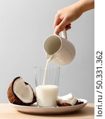front view hand pouring coconut milk glass. High resolution photo. front view hand pouring coconut milk glass. High quality photo. Стоковое фото, агентство Ingram Publishing / Фотобанк Лори
