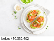 Open sandwiches with salted salmon, guacamole avocado and microgreens. Seafood. Healthy food. Top view. Стоковое фото, агентство Ingram Publishing / Фотобанк Лори