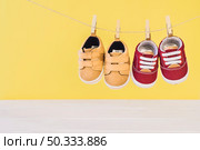 newborn concept with two shoes clothesline. Стоковое фото, агентство Ingram Publishing / Фотобанк Лори
