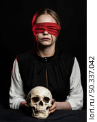 woman with red blindfold holding skull. Стоковое фото, агентство Ingram Publishing / Фотобанк Лори