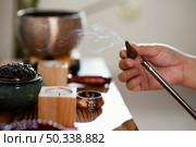 side view man lighting incense. Стоковое фото, агентство Ingram Publishing / Фотобанк Лори
