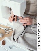 high angle seamstress using sewing machine. Стоковое фото, агентство Ingram Publishing / Фотобанк Лори