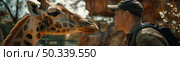 A man in casual attire stands beside a tall giraffe in a zoo habitat, observing the majestic animal up close. Стоковое AI-изображение, AI-художник Данила Большаков / Фотобанк Лори