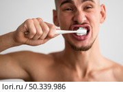 front view man brushing his teeth morning. Стоковое фото, агентство Ingram Publishing / Фотобанк Лори