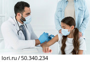 male doctor vaccinating little girl that s supported by her mother. Стоковое фото, агентство Ingram Publishing / Фотобанк Лори