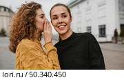 portrait teenager whispering her friends ear. Стоковое фото, агентство Ingram Publishing / Фотобанк Лори