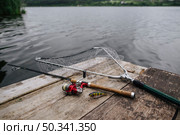 fishing rod with lure net wooden pier idyllic lake. Стоковое фото, агентство Ingram Publishing / Фотобанк Лори