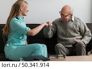 old man nursing home fist bumping nurse. Стоковое фото, агентство Ingram Publishing / Фотобанк Лори