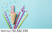 waffle cone with number one candle streamer drinking straws blue background. Стоковое фото, агентство Ingram Publishing / Фотобанк Лори
