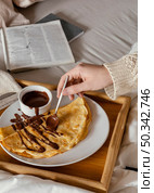close up hand spreading chocolate pancake. Стоковое фото, агентство Ingram Publishing / Фотобанк Лори