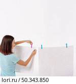 back view woman arranging towels clothesline. Стоковое фото, агентство Ingram Publishing / Фотобанк Лори