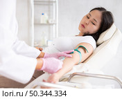 Doctor drawing blood from the elderly woman vein. Стоковое фото, фотограф Яков Филимонов / Фотобанк Лори