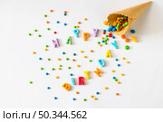 happy birthday text with candies spilling from waffle ice cream cone. Стоковое фото, агентство Ingram Publishing / Фотобанк Лори