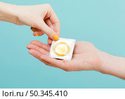woman giving condom another person. Стоковое фото, агентство Ingram Publishing / Фотобанк Лори