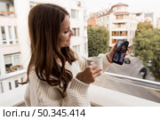 woman home video calling friends quarantine with coffee. Стоковое фото, агентство Ingram Publishing / Фотобанк Лори
