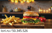 Delicious burger and French fries in home kitchen with Christmas decor, lights of garland. Delivery from fast food restaurant, menu burger home cooking for New year. AI generated; Стоковое AI-видео, аниматор Ольга Симонова / Фотобанк Лори