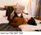 back view woman reading book bed. Стоковое фото, агентство Ingram Publishing / Фотобанк Лори