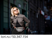 blonde fashionable young woman with hand hips looking away. Стоковое фото, агентство Ingram Publishing / Фотобанк Лори
