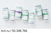 rolled up one hundred us dollar bills tied with rubber white background. Стоковое фото, агентство Ingram Publishing / Фотобанк Лори