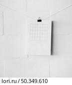 am empty table paper attach string with paperclip against white wall. Стоковое фото, агентство Ingram Publishing / Фотобанк Лори