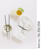 top view incense stick pumice stone flower gingko leaf oil tied napkin white background. Стоковое фото, агентство Ingram Publishing / Фотобанк Лори