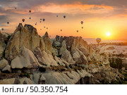Hot air balloons over rocks in Cappadocia. Air balloons over rocks. Стоковое фото, агентство Ingram Publishing / Фотобанк Лори