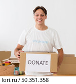 happy volunteer holding donate box. Стоковое фото, агентство Ingram Publishing / Фотобанк Лори