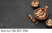 pistachio nuts bowls with wooden spoons copy space. Стоковое фото, агентство Ingram Publishing / Фотобанк Лори