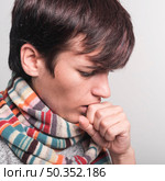 woman wearing multicolored scarf around neck coughing against gray backdrop. Стоковое фото, агентство Ingram Publishing / Фотобанк Лори