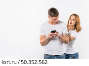 boyfriend looking her girlfriend secretly looking cellphone. Стоковое фото, агентство Ingram Publishing / Фотобанк Лори