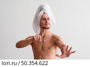 front view shirtless man with towel his head looking his fingernails. Стоковое фото, агентство Ingram Publishing / Фотобанк Лори