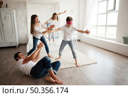 father lying floor while family playing blind man s buff home. Стоковое фото, агентство Ingram Publishing / Фотобанк Лори