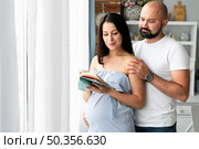 husband pregnant wife searching baby names. Стоковое фото, агентство Ingram Publishing / Фотобанк Лори