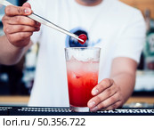 male bartender decorating drink with cherry. Стоковое фото, агентство Ingram Publishing / Фотобанк Лори