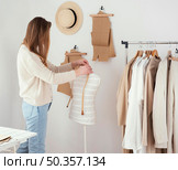 side view female tailor studio with clothes. Стоковое фото, агентство Ingram Publishing / Фотобанк Лори