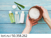 close up hand holding bowl rock salts with aloevera spray bottles cream. Стоковое фото, агентство Ingram Publishing / Фотобанк Лори