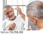 close up man applying face serum. Стоковое фото, агентство Ingram Publishing / Фотобанк Лори