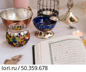 OLYMPUS DIGITAL CAMERA. close up shot opened quran festive table. Редакционное фото, агентство Ingram Publishing / Фотобанк Лори
